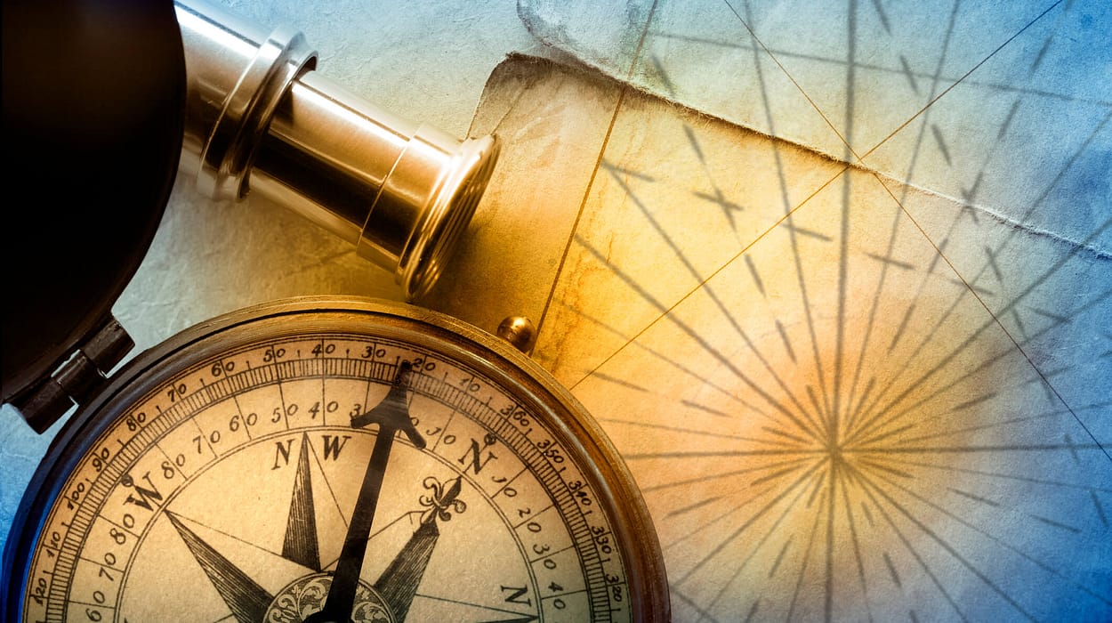 An antique brass compass resting on a nautical chart in warm light, symbolizing the strategic navigation of retirement planning.